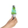 A small hand holding a miniature Lava Lamp with green floating globs inside. The lamp has a silver base and cap, and the liquid inside is blue. The background is white.
